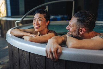 Couple relaxing in hot tub enjoying wellness spa treatment