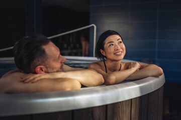 Couple relaxing in hot tub enjoying wellness spa treatment