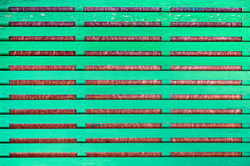 Horizontal green slats alternating with brown textured background, abstract pattern on fence. Fence structure, minimalism, frame backdrop, trendy color