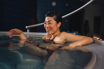 Woman smiling relaxing in hydrotherapy hot tub