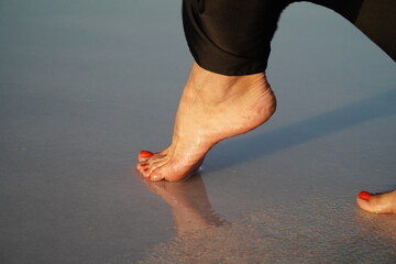 A view of women's feet near the water on a salt lake