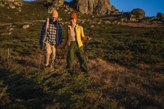 Couple hiking mountain holding hands enjoying togetherness - Powered by Adobe