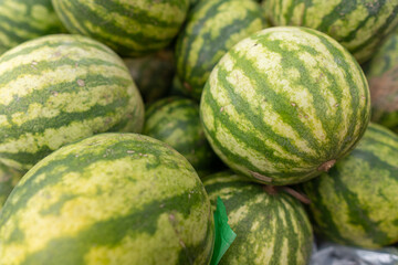 Watermelons with green striped skin at open-air fruit stand