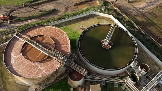 Top down aerial view of clarifying tanks, bubbling water mixed for cleaning and processing factory works, sugar food production industry, Newark-on-Trent, United Kingdom 