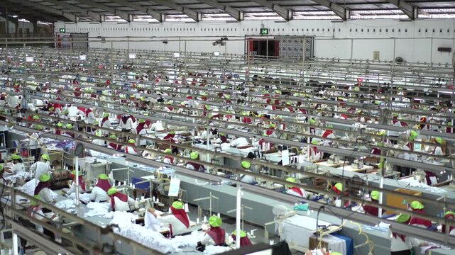 Sewing machine factory crowded Factory employee. Worker activity in a textile factory. factory worker sewing gloves using modern sewing machines