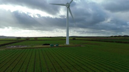 Aerial drone view of single wind turbine windmill in rural green field surrounded by crops and rolling landscapes, green energy generation renewable power plant, Nottingham, United Kingdom, Europe - Powered by Adobe