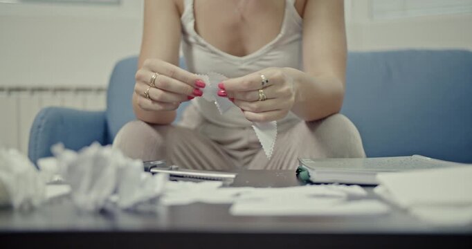 Watch a woman's hands meticulously create diverse paper sounds, tearing, crumpling, and rustling pages. Ideal for foley art, ASMR content, or sound design projects requiring authentic, ambient audio.