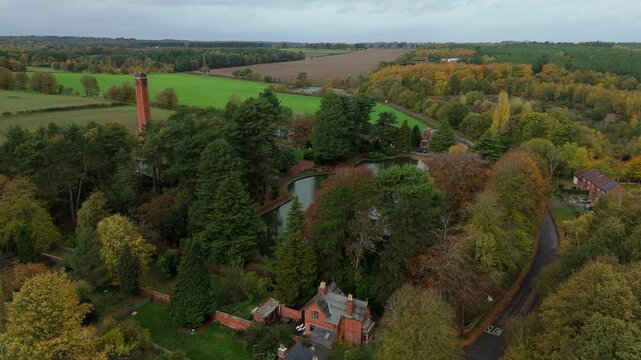 Drone footage of Victorian pumping station nestled in rural Nottingham with scenic hills, woodland, and water features in the English countryside
