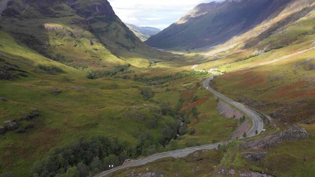 Scenic drone view of a road winding through highlands in Scotland near Glencoe