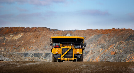 Massive Mining Dump Truck Transporting Ore in Open Pit Mine at Sunset © Parilov