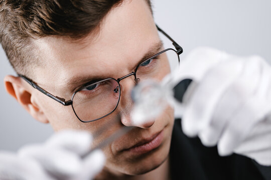 Portrait Caucasian male jeweler examining diamond with precision tools