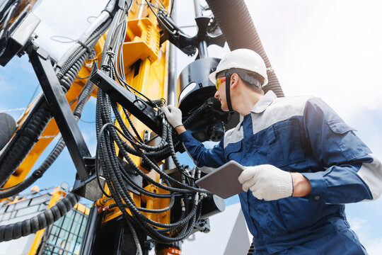 Technology in industrial geological exploration of oil. Industry operator use computer tablet for control drilling rig offshore.