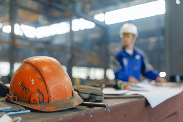 Shipyard interior with focus on safety helmet and worker in cargo industry port