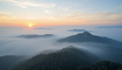 Aerial view of mountains at sunrise surrounded by misty landscape