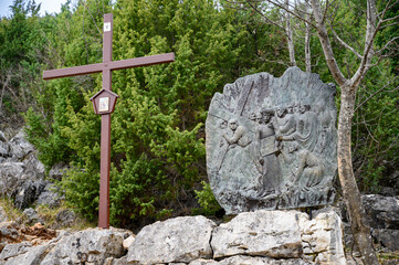 Station V: Simon of Cyrene helps Jesus carry the Cross. The Way of the Cross on Mount Križevac (the Cross Mountain) in Medjugorje.