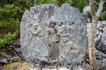 Station V: Simon of Cyrene helps Jesus carry the Cross. The Way of the Cross on Mount Križevac (the Cross Mountain) in Medjugorje.