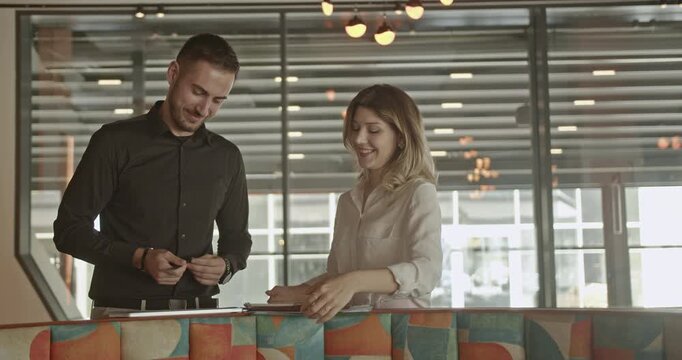 Smiling business partners are collaborating and discussing documents in a modern office environment. Their dedicated teamwork contributes to the growth and success of their small business.