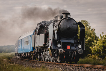 Naklejka premium Classic steam locomotive moving. History and power on the rails.