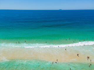Aerial view of people surfing on crystal clear water in Copacabana Beach, Rio de Janeiro