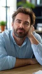 Contemplative professional relaxing at work with thoughtful pose, sunlight reflecting softly around.