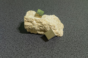 natural pyrite specimen featuring perfect cubic crystals within a sedimentary rock matrix. The image highlights geometric mineral structure, metallic luster, and the harmony between nature a