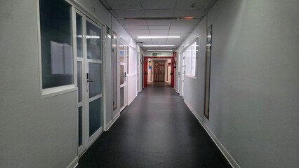 Empty hospital corridor with clinical atmosphere and emergency exit sign