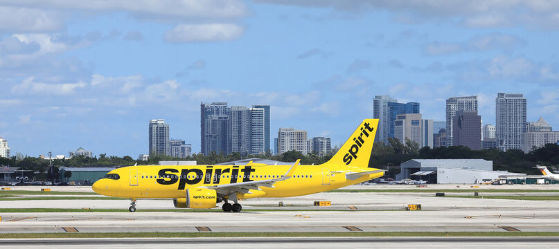 Spirit Airlines jet on its way to takeoff with the Fort Lauderdale skyline in the background, Fort Lauderdale, Florida, USA. 