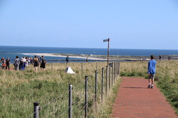 Touristen gehen auf der Hochseeinsel Helgoland in Deutschland spazieren 