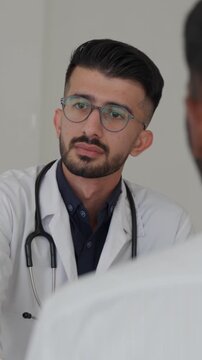 Vertical video medical team in a modern clinic conference room collaborating on a patient's diagnosis and treatment plan during meeting