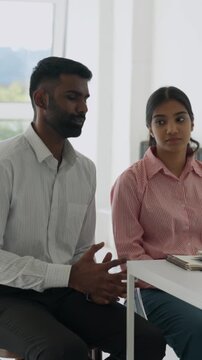 Vertical video concerned indian couple sharing personal struggles with a psychologist in a group therapy session seeking support and guidance