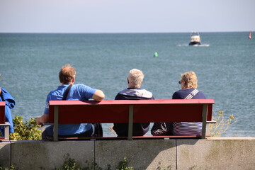 Touristen sitzen auf einer Bank auf der Hochseeinsel Helgoland in Deutschland 