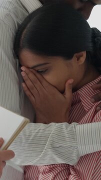Vertical video male husband comforts distressed young woman wife crying in hospital after receiving upsetting medical news, showing empathy, family couple suffering
