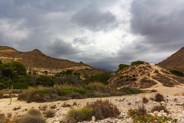 a beautiful view of a rocky mountain road and a stormy sky
