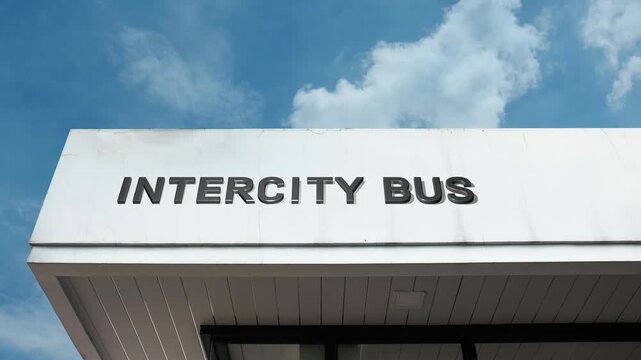 Intercity Bus sign displayed on the transport terminal facade beneath a clear blue sky, signifying a station for long-distance coach travel and scheduled transit between metropolitan areas.