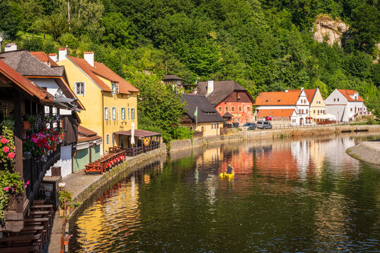 Kayaker with reflections of historic Old Town Cesky Krumlov on the River Vitava.
