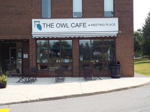 Ottawa, ON, Canada-June 24,2025:The exterior of a brick building featuring the "THE OWL CAFE &bull; MEETING PLACE" at 1140 Morrison Drive unit 106A.
