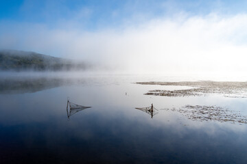 Dawn at Lake Toro with fishing nets casting shadows under the water
