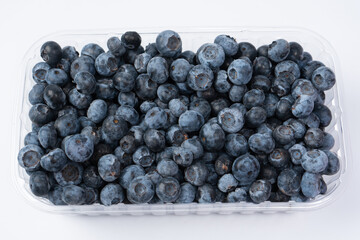Blueberries in a plastic container isolated on a white background.