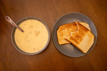 Homemade Potato and Bacon Soup with Sourdough Toast on Wooden Table