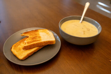 Homemade Potato and Bacon Soup with Sourdough Toast on Wooden Table