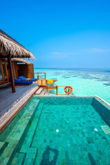 Tranquil closeup calm sea water waves with palm trees. Cabin with pool. Tropical island beach landscape exotic shore coast. Summer vacation, holiday amazing nature. Relax paradise, Maldives.