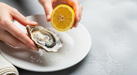 person squeezing lemon juice on fresh oyster ready to eat on white plate in restaurant
