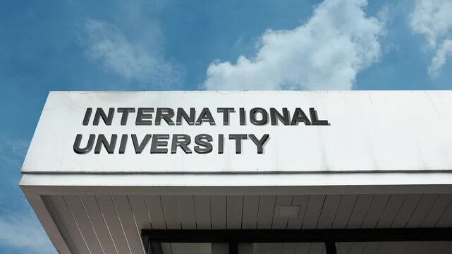 International University word sign displayed on building facade under clear blue sky, representing advanced global education, cross-border research, and diverse student populations.