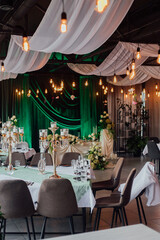 Elegant wedding venue decor with green drapes and romantic lighting