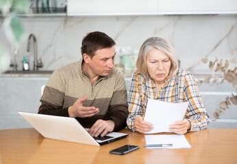 Obraz premium Male agent showing presentation and making offer to old woman