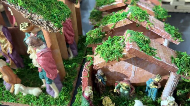 Christmas holiday decorations showing multiple nativity scenes with the holy family, baby jesus in a manger, the three wise men, shepherds, and animals in a detailed miniature village setting