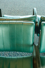 green leather wrapped seats with arm rests face back to back at the downtown bus terminal public waiting area