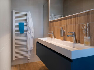Contemporary bathroom featuring floating vanity heated towel radiator and wood accent tile wall
