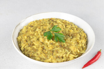 Indian khichri, kichri with rice, lentils and spices on grey background. Top view. Ayurvedic diet.