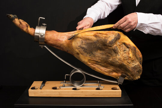 Jam&oacute;n sobre jamonero preparandolo para limpieza y corte con emplatado.